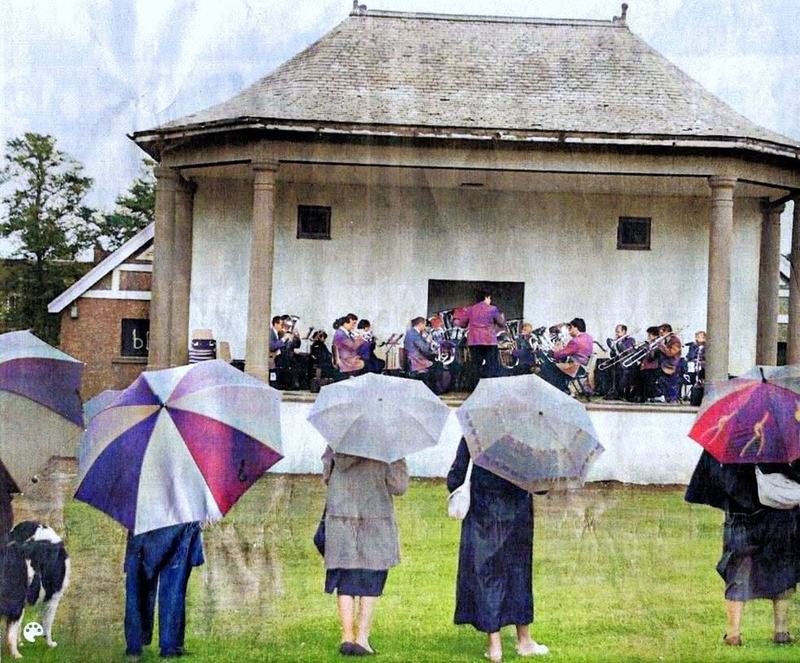 A brass band playing at the Kings Park bandstand, the audience under umbrellas