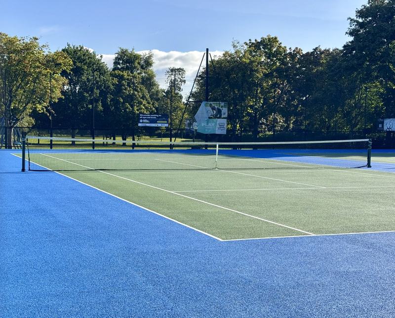 The courts after the 2024 resurfacing, with the Free Park Tennis banner on the fence